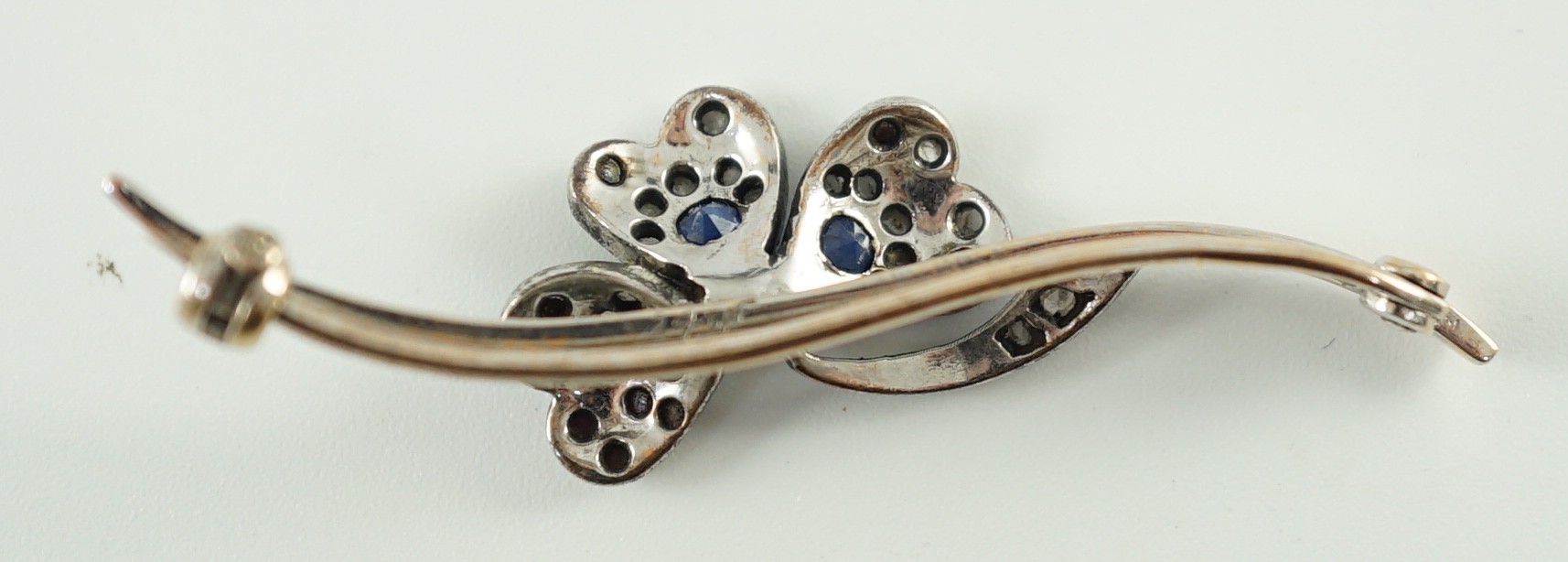 A 1920’s white gold, sapphire, cultured pearl and rose cut diamond set shamrock bar brooch